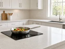 Portable induction cooktop on a College Station kitchen counter with a skillet of vegetables